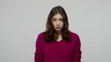 Unhappy brunette woman in pullover is about to cry with resentful naughty face expression