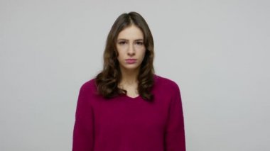 Offended angry brunette woman in pullover showing middle finger, rude sign of disrespect, gesturing fuck off