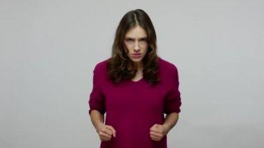 Anger management problems. Brunette woman in pullover looking at camera with furious eyes