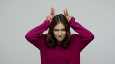 I'm a cow! Funny childish nice-looking woman in pullover making bull horn gesture and pretending to attack