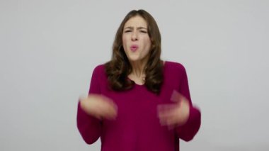 What do you want? Annoyed brunette woman in pullover waving hands in questioning gesture why