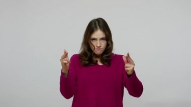 Dangerous criminal brunette woman threatening with finger pistols, shooting to camera, making control shot