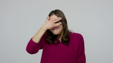Funny nosy brunette woman in pullover being curious about secret watching through fingers with prying eyes