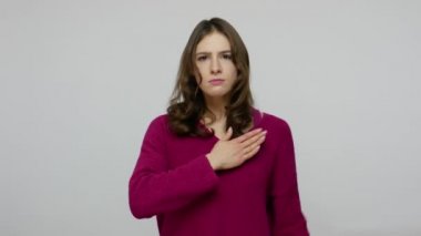 Responsible brunette woman in pullover looking into camera with devoted eyes, making promise