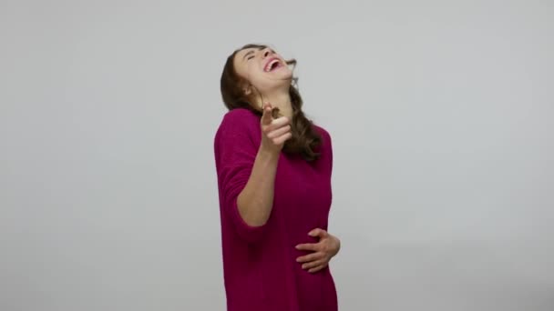 Je bent belachelijk! Overblij geamuseerde brunette vrouw in pullover barsten in lachen en wijzen naar camera — Stockvideo