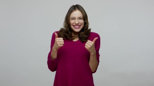 Ентузіазм щаслива красива брюнетка жінка робить подвійні великі пальці вгору жестом і посміхається — стокове відео
