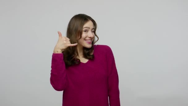 Hey you, call me! Attractive woman in pullover showing telephone gesture with fingers and pointing to camera — Stock Video