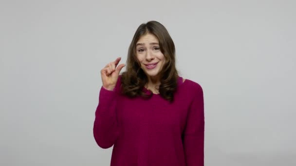 Brauchen etwas mehr. nett aussehende brünette Frau im Pullover zeigt eine kleine Geste mit skeptischem Lächeln — Stockvideo