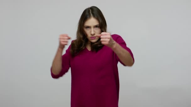 Aggressive brunette woman in pullover threatening to punch, boxing at camera with angry furious expression — Stock Video