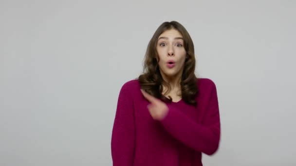 Menina morena fascinante com rosto surpreso surpreso apontando para espaço de cópia, mostrando área de publicidade — Vídeo de Stock