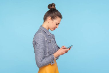 Hafif kambur saçlı, cep telefonu kullanan kadının yan görüntüsü.