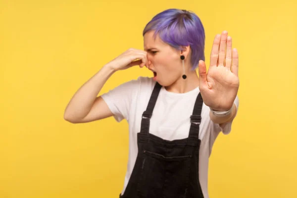Portrait of displeased hipster girl pinching her nose and showin — Stock Photo, Image