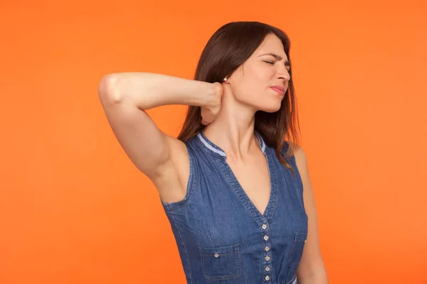 Pijn in de nek. Moe ongezonde brunette vrouw in denim jurk stan — Stockfoto