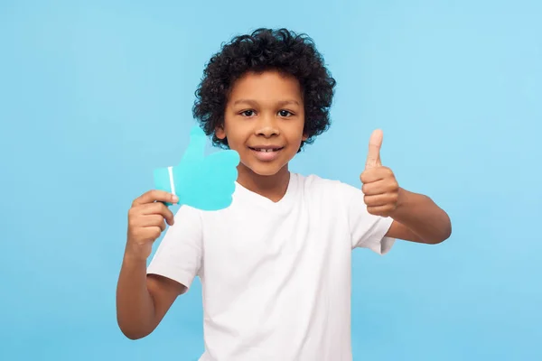 Portrait of positive nice preschool boy with curly hair showing — Stock Photo, Image