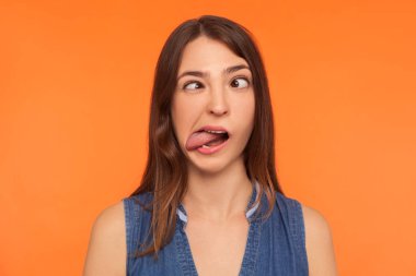 Closeup of silly dumb brunette woman demonstrating tongue and ma