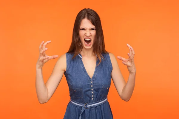 Crazy mad brunette woman in denim dress screaming angrily with f — Stok fotoğraf