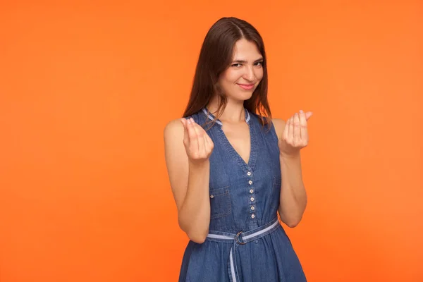 Attractive brunette woman in casual denim dress showing money ge — Stok fotoğraf