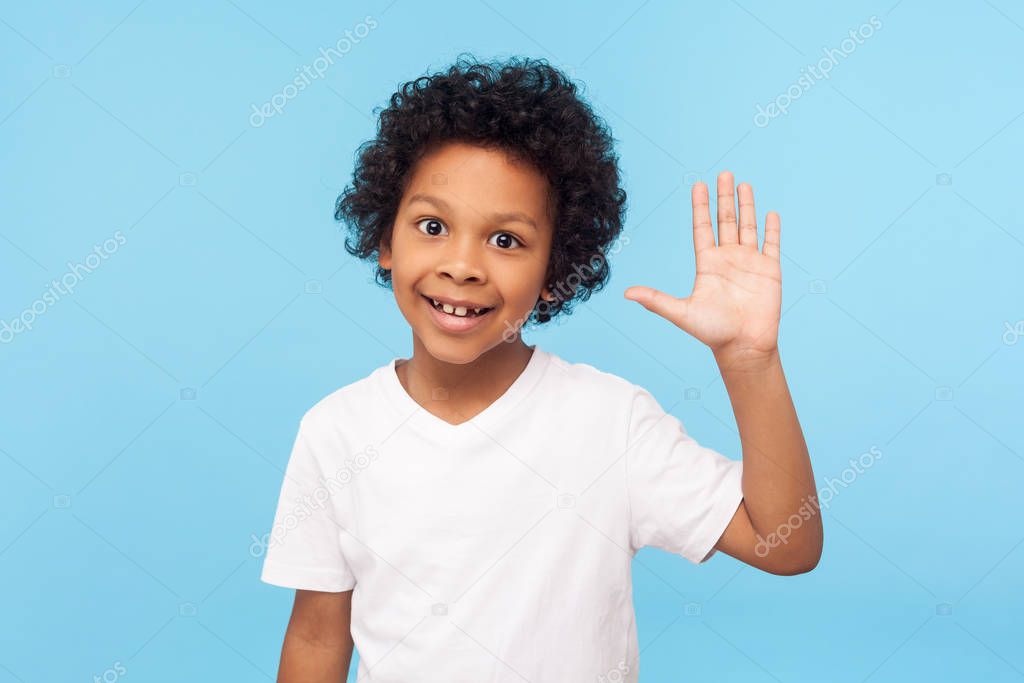 Portrait of amazing friendly little boy grinning happily and wav