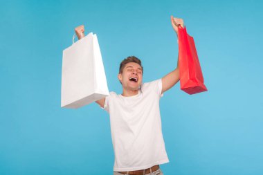 Overjoyed ecstatic man in t-shirt shouting enthusiastically and 