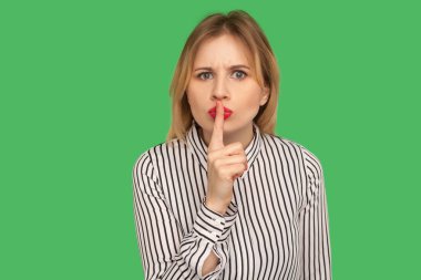 Don't speak! Serious teacher in striped blouse looking angrily a