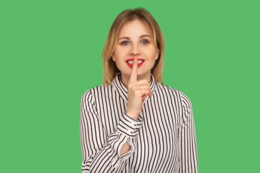 Beautiful happy teacher in classic striped shirt holding finger 