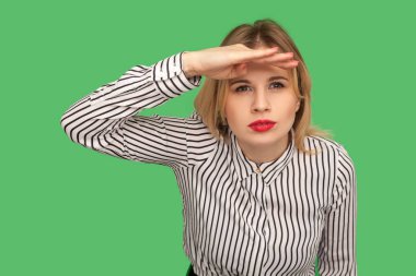Curious young woman with red lips in striped blouse keeping palm