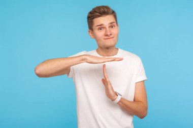 Ara vermem gerek, lütfen! Sıradan beyaz tişörtlü bir işçinin portresi mola hareketi gösteriyor ve durmak istiyor, durmak için yalvarıyor, itişmek yok. Mavi arka planda kapalı stüdyo çekimleri