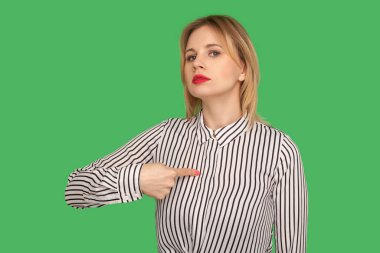 Ben buyum! Mükemmel kırmızı dudakları olan, kendini gösteren, kibirli bir ifadeyle bakan, gururlu ve kendine güvenen güzel sarışın kız. Yeşil arka planda izole edilmiş kapalı stüdyo çekimi