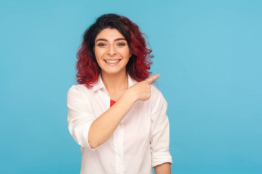 Reklam alanı, fikir sunumu. Beyaz tişörtlü, süslü, kırmızı saçlı neşeli hippi kadın yan yana, reklam için fotokopi odası gösteriyor. Mavi arka planda kapalı stüdyo çekimleri