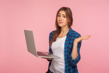 Oops, işe yaramıyor! Karman çorman tişörtlü, dizüstü bilgisayarı olan, çaresiz bir hareketle elini kaldıran, yazılım hatası ve program hatası için endişelenen bir kız. Pembe arka planda kapalı stüdyo çekimleri
