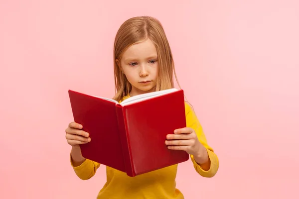 Умная Симпатичная Маленькая Девочка Читающая Большую Книгу Серьезным Внимательным Выражением — стоковое фото