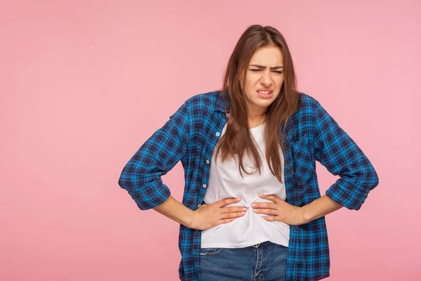 腹部疼痛 阵发性抽筋 描述穿着格子衬衫的不幸病女 她紧紧抓住肚子痛 胃炎或便秘的腹部 在粉红背景下隔离的室内拍摄 — 图库照片