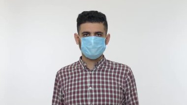 Mutlu adam tıbbi maskeyi çıkarıyor ve kameraya gülümsüyor, grip hastalığından kurtulduğu için seviniyor, 2019-nCoV koronavirüsü, güçlü bağışıklık sistemi olan pozitif ve sağlıklı bir adam. Stüdyo çekimi, izole