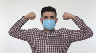 Tıbbi maskeli bir adam güç, sağlıklı vücut konsepti ve güçlü bağışıklık sistemi, bulaşıcı enfeksiyonlara direnç gösteren, Coronavirus 2019-nCoV 'u gösteriyor. Stüdyoda çekim izole edildi