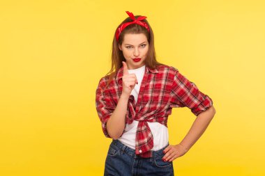 Söylemiştim sana! Kareli gömlekli ve bantlı kızın portresi uyarı niteliğinde jestlerle, uyarı niteliğinde patronluk taslayarak, konsept değiştirerek öğretiyor. Retro 50 'ler tarzı, stüdyo çekimi, sarı arkaplan