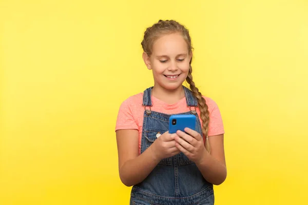 소녀가 핸드폰으로 메시지를 네트워크에서 수다를 떨면서 모바일 애플리케이션으로 만족하는 스튜디오 — 스톡 사진