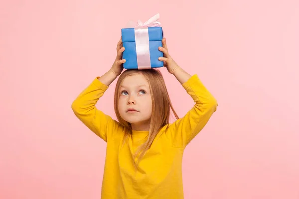 Портрет Вдумливої Маленької Дівчинки Тримає Подарунок Голові Дивиться Вгору Зухвалим — стокове фото