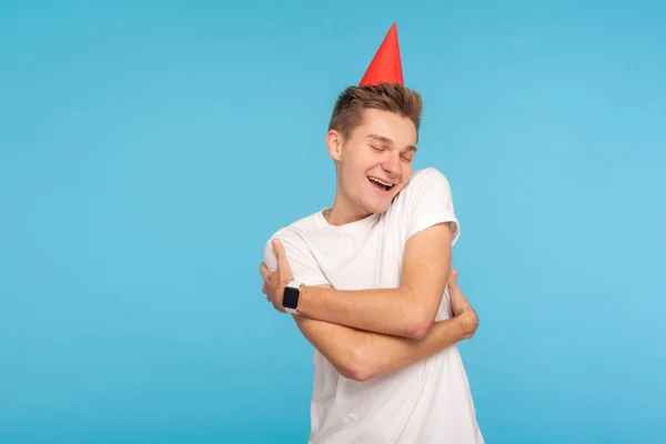 誕生日おめでとう 喜びの表現で自分自身を受け入れ 頭の上にパーティーコーンと面白い正の男は 一人で休日を祝うために幸せ 自己愛の概念 スタジオ撮影青の背景 — ストック写真
