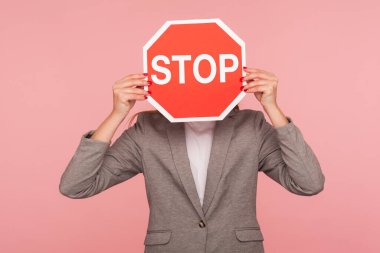 Takım elbiseli bir iş adamının portresi yüzünü Dur sembolüyle kaplayan, elinde kırmızı trafik ışığı tutan kimliği belirsiz bir kadın, tehlike uyarısı, kısıtlama ve sınırlar. Stüdyoda çekim izole edildi