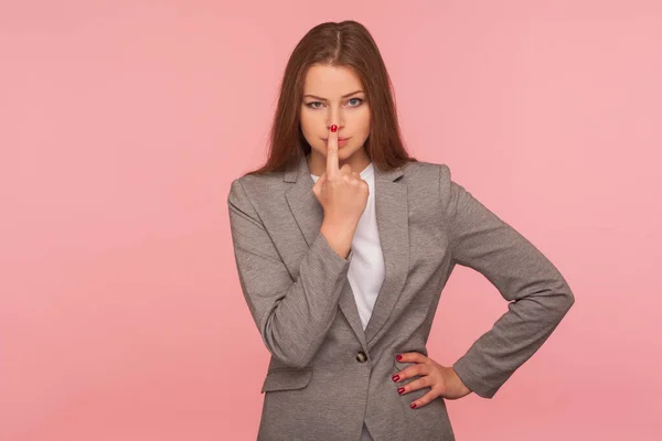 I don\'t believe, you are liar! Portrait of dissatisfied young woman in business suit touching nose showing lie gesture, suspecting cheating, body language. studio shot isolated on pink background