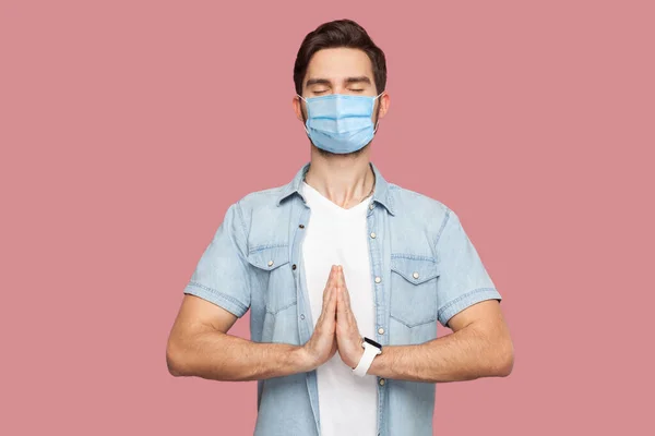 Portret Spokojnego Młodzieńca Chirurgiczną Maską Medyczną Niebieskiej Koszuli Stojącej Dłońmi — Zdjęcie stockowe