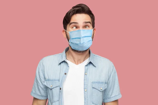 Portret Szalonego Młodego Człowieka Chirurgicznej Masce Medycznej Niebieskiej Koszuli Stojącego — Zdjęcie stockowe