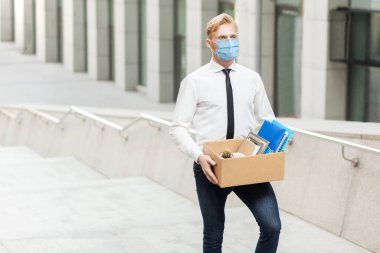Cerrahi maskeli beyaz gömlekli genç adamın yeni bir işi var. Daha iyi bir işe gidiyorum. Merdivenlerde çekim yapmak, işi yükseltmek, çalışmak ve sağlık hizmetleri kavramı.