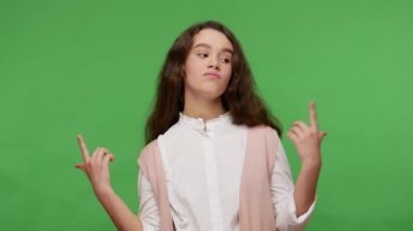 Ben en iyisiyim! Egoist, güzel, beyaz gömlekli esmer kız kendini gösteriyor ve kibirle bakıyor, kendine güveni tam başarılı hissediyor. Yeşil arka planda izole edilmiş kapalı stüdyo çekimi