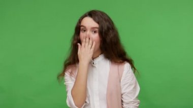 Kimseye anlatmayacağım! Beyaz gömlekli korkmuş esmer kız ağzını kapatıyor ve sonsuza kadar sır saklayacağına söz veriyor. Gizli bilgi. Yeşil arka planda izole edilmiş kapalı stüdyo çekimi