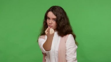 Bana doğru gel! Beyaz tişörtlü esmer bir kız parmağıyla işaret ediyor, ona yaklaşmayı talep ediyor, otoriter görünüyor. Yeşil arka planda izole edilmiş kapalı stüdyo çekimi
