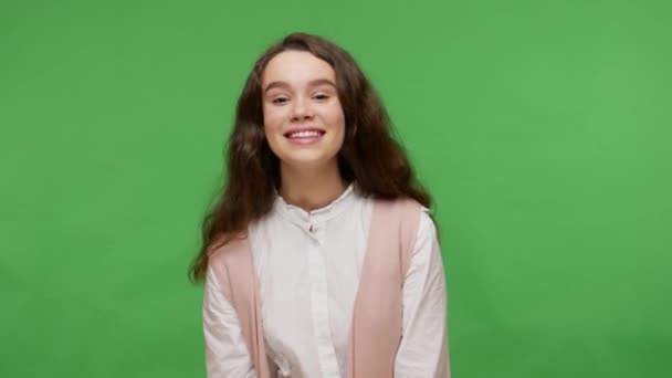 셔츠를 스러운 소녀가 카메라를 흔들며 무표정하게 웃으면서 긍정적 감정을 스튜디오 — 비디오