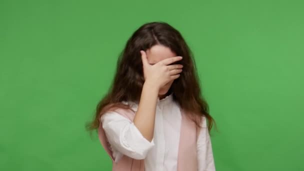 見たくない 白いシャツを着た動揺10代のブルネットの少女は目を閉じて 何か不快な恥ずべき ジェスチャーを停止し 問題を避けるために表示されません 緑の背景に隔離された屋内スタジオで — ストック動画