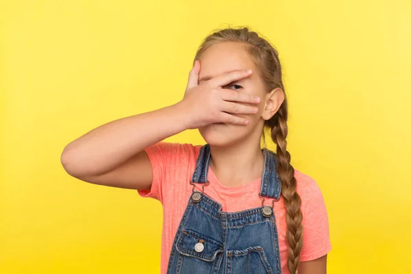 Portrait Inquisitive Little Girl Braid Denim Overalls Covering Face Hand — Stock Photo, Image