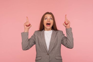 Vay canına, reklamlara bak! Takım elbiseli, şaşırmış genç bir kadının portresi. Ticari fikir ve sunum için fotokopi alanı gösteriyor. Stüdyo çekimi izole